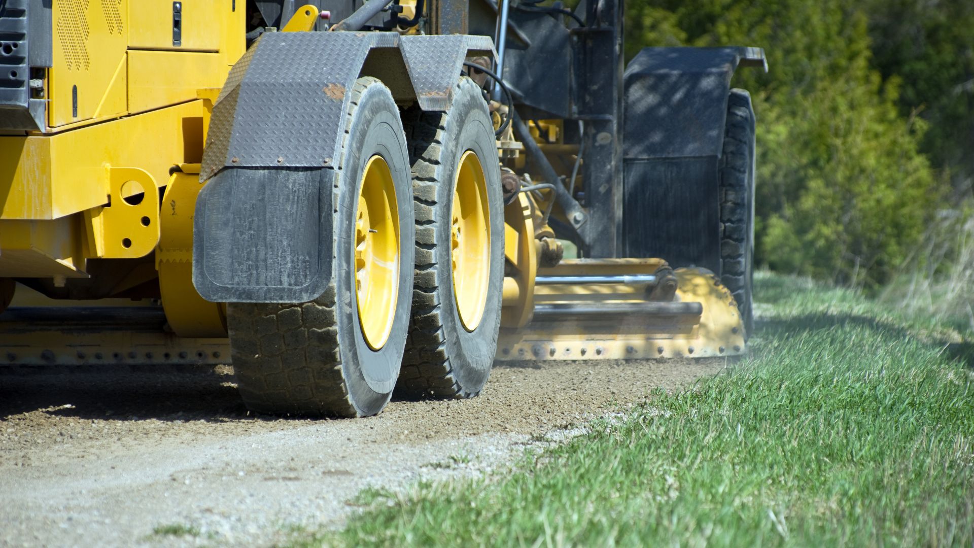 A tractor is driving down a dirt road