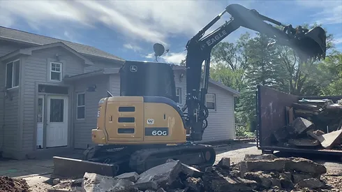 A construction vehicle is parked in front of a house